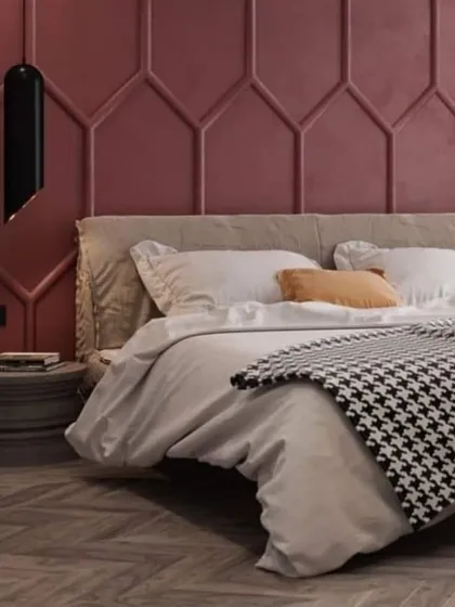 A bedroom with a bold, geometric-paneled accent wall in a deep raspberry color. The simple, low bed and houndstooth throw create a stylish contrast.