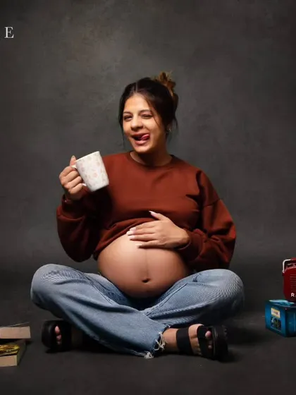 Capturing the real, fun, and casual side of pregnancy. This relaxed portrait of a mom-to-be with her bare bump, a cozy sweater, and a cup of coffee shows that maternity photos can be modern, relatable, and full of personality.