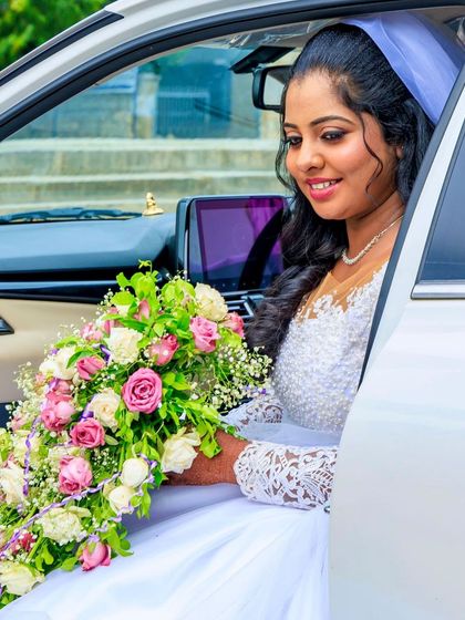 A happy bride ready to go to her wedding. She is holding a beautiful bouquet, and her makeup is fresh and glowing.