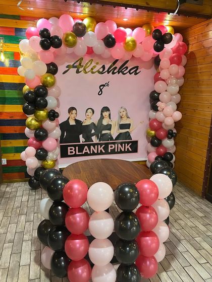 A stylish Blackpink themed birthday for an 8-year-old fan. The pink, black, and gold balloon arch frames a custom backdrop of the popular K-pop group.