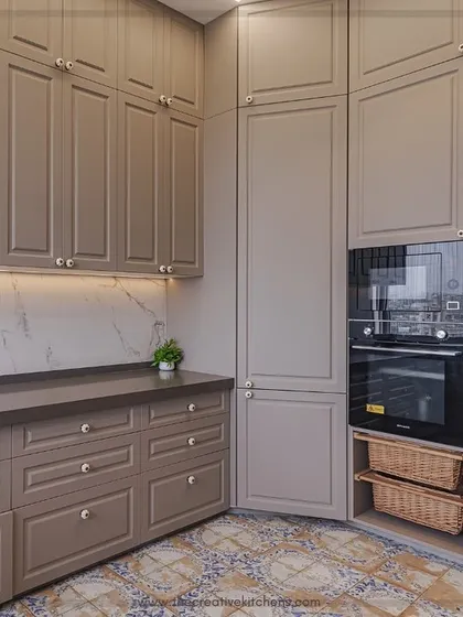 We seamlessly integrate modern appliances, like the built-in oven and microwave, into the classic cabinetry design. The addition of wicker baskets adds a touch of rustic, bohemian texture to the space.
