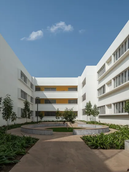 A sheltered courtyard at Vidyashilp Academy provides a quiet, contemplative space for students. These green pockets are integrated throughout the campus to draw daylight and air into the heart of the buildings and offer places for rest and social interaction.