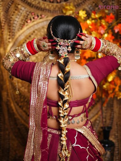 A view of the intricate bridal braid, adorned with traditional gold accessories, a key skill in our hairstyling course.