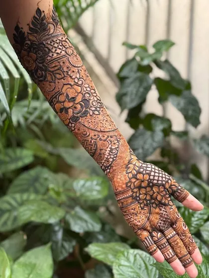 A beautiful full-arm design with a mix of floral and geometric patterns, set against a natural green background.