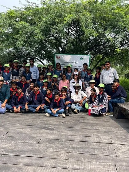 A group photo of the Bry-Air team and the children on the wooden deck at Aravali Nagar Van. This collaboration inspires the next generation to protect our planet.