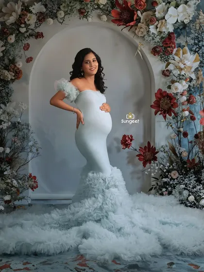 A confident and joyful pose in the light blue gown, showcasing the beautiful silhouette of the baby bump.