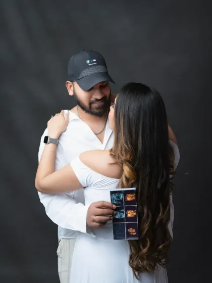 Sharing the first glimpse of their baby. The couple looks lovingly at their ultrasound photos, a beautiful memory of the very beginning of their journey.