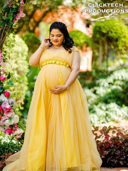 Another beautiful solo maternity portrait in the yellow gown by the floral arch.