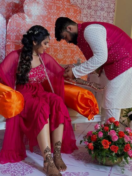 A sweet moment where the groom admires the bride's mehndi. This shot gives a glimpse of both her hand and foot designs.