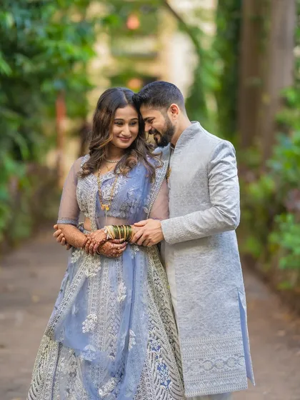 A beautiful portrait of Saurabh and Aishwarya in a lush green pathway. Their coordinated pastel outfits look stunning against the natural backdrop.