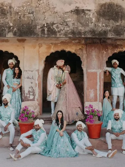 A creative group portrait with the couple and their wedding party. This editorial style shot, set against ancient palace arches, is a fun and memorable way to capture the entire crew.