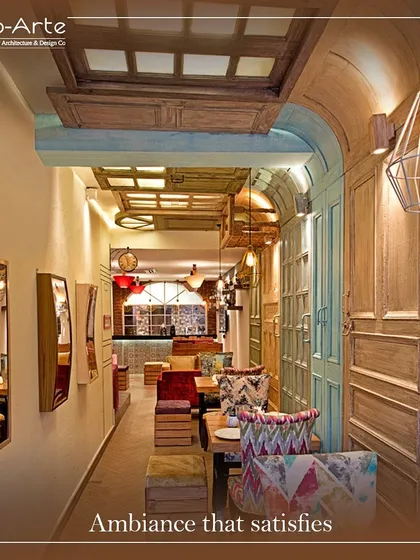 The ambiance at Café Hera Fehri is designed to satisfy. The narrow space is made to feel grand with a ceiling of reclaimed wooden doors, eclectic furniture, and warm, industrial-style lighting.