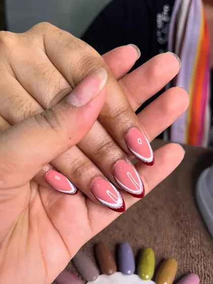 A close-up of this modern red and white double French design, showing the clean lines and almond shape before the final top coat.