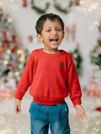 The pure, unfiltered excitement of childhood is what makes festive photoshoots so special. This little boy's radiant smile against the backdrop of our Christmas setup is a perfect example of the holiday magic we can create together.
