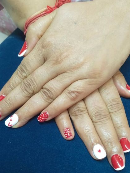 A fun and playful set featuring red and white gel polish. I created a mix of designs, including polka dots, tiny hearts, and a larger heart on the accent nail. This kind of custom mix-and-match art is great for any fun occasion.