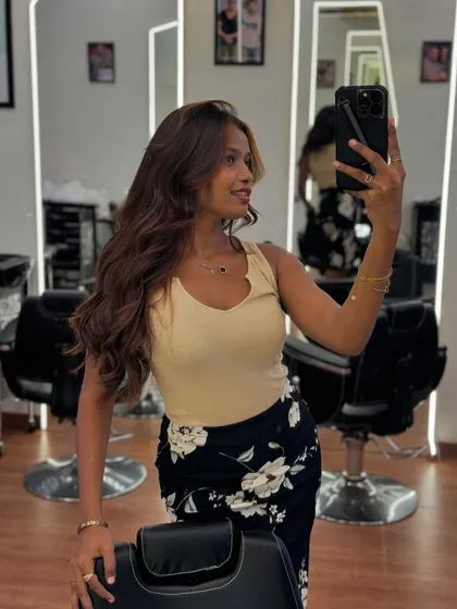 Another angle of a client's mirror selfie, showing off her new hair color and style from the side.