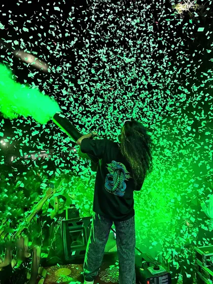 I love using special effects to elevate the experience. Here I am with a CO2 gun, blasting green smoke and confetti over the crowd to create a truly memorable and high-impact moment during my set.