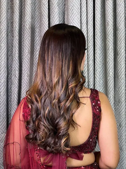 A view of the back, showing off the beautiful, bouncy curls and rich hair color. This hairstyle is perfect for adding volume and movement.