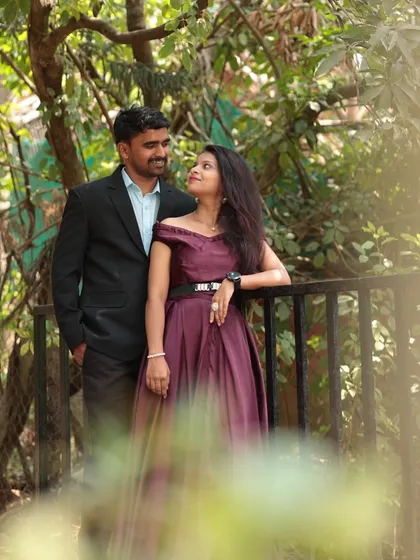 A sweet pre-wedding moment on a bridge. The deep wine-colored off-shoulder gown is an elegant and sophisticated choice for an outdoor shoot.