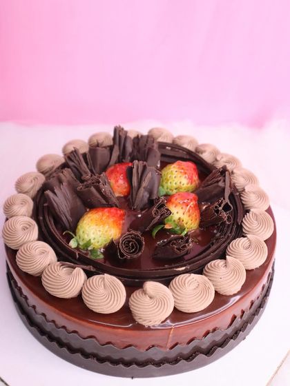 A classic combination of rich chocolate and fresh strawberries. This cake is perfect for Valentine's Day, with chocolate shavings, swirls of frosting, and juicy strawberries on top.