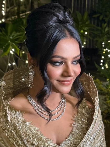 A close-up of the bride's happy expression, her elegant high bun completing the glamorous evening look.
