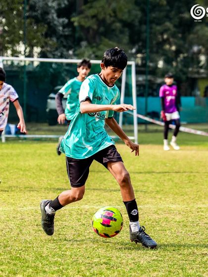 A player dribbles confidently, weaving through the opposition during a U13 Pride Cup match.