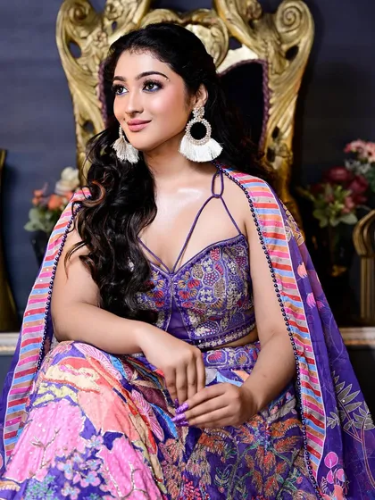 A seated portrait in our colorful printed lehenga with a cape. This outfit combines comfort and high fashion, making it a great choice for a long event.