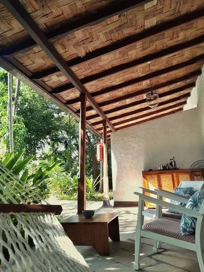 The private veranda of the Garden Suite's blue room, complete with a hammock and comfortable seating. The ceiling is made of woven bamboo, adding to the tropical feel.