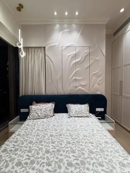 A full view of the bedroom, showcasing the 3D textured panel behind the bed, which acts as a stunning piece of wall art. The pendant lights add a touch of modern elegance.