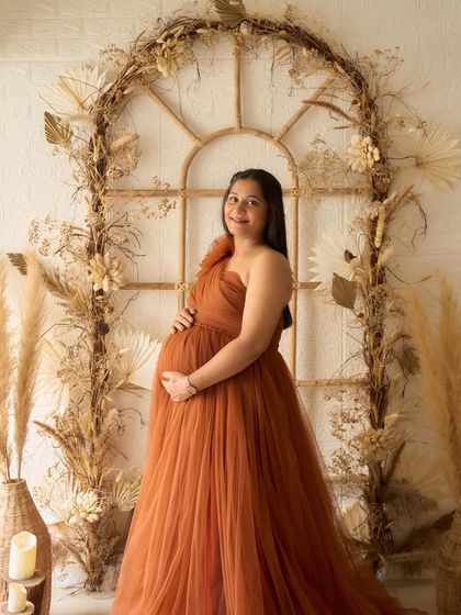 A full-length portrait of our Copper gown in the studio. The warm, earthy tone of the dress pairs perfectly with our boho-themed backdrop.