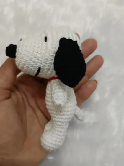 A side view of my handmade crochet Snoopy charm. You can see the detail in the ears and tail, all made with soft yarn.