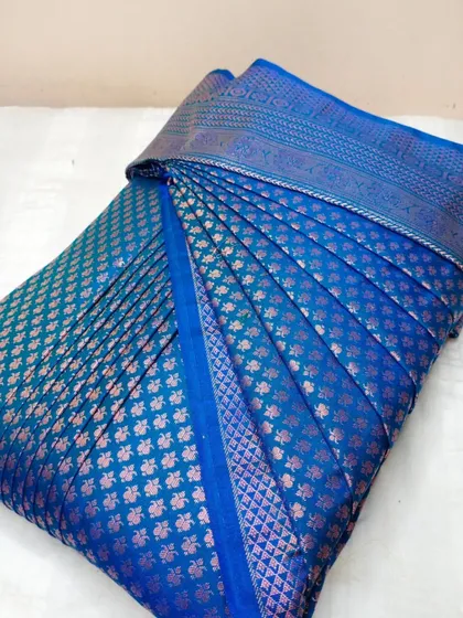 A blue brocade saree with pink and gold details.