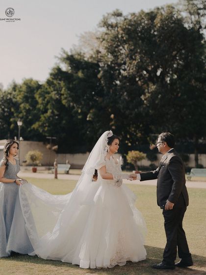 A touching moment between the bride and her father. Her elegant updo and soft makeup create a classic and graceful bridal profile.