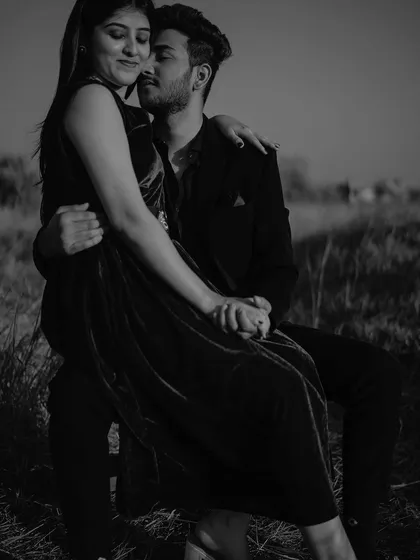 An intimate black and white portrait. Her arms around him, they share a quiet moment of closeness that feels both tender and powerful.