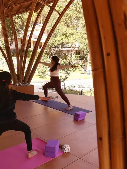 Students hold Virabhadrasana II (Warrior II) during a retreat session. This powerful pose builds strength and stamina, reflecting the resilience we cultivate when we immerse ourselves in practice and nature.