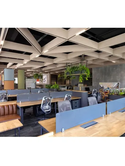 The open-plan workspace at Paras Healthcare features an innovative ceiling design with acoustic panels, ensuring a comfortable sound environment. The layout is designed to be flexible, with a mix of individual workstations and collaborative benches.