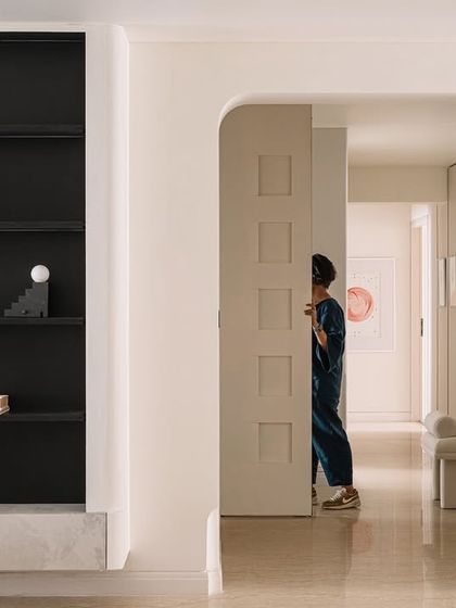 Another view of the sliding panels that separate the living areas. The person in motion gives a sense of the home's scale and flow.