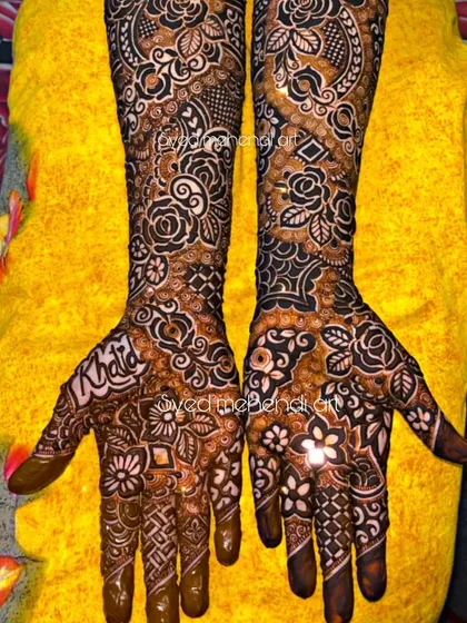 A full bridal design with the groom's name "Khalid" written on the palm.