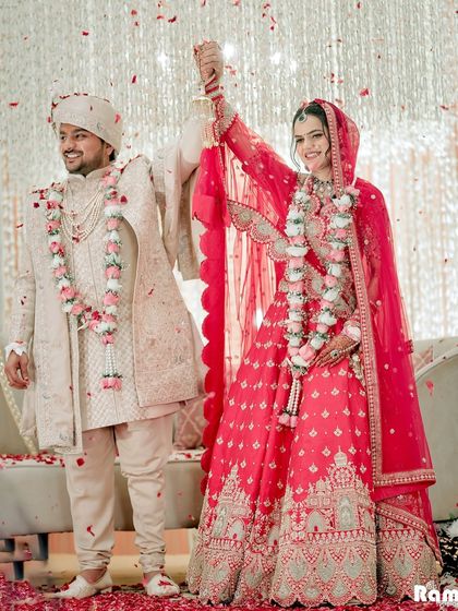 A moment of pure happiness as the couple celebrates their union on stage, showered with flower petals.