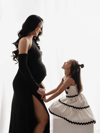 A beautiful moment between mother and daughter. The way her little girl looks up at her is just priceless. It’s a precious portrait of the bond they share before the new baby arrives.