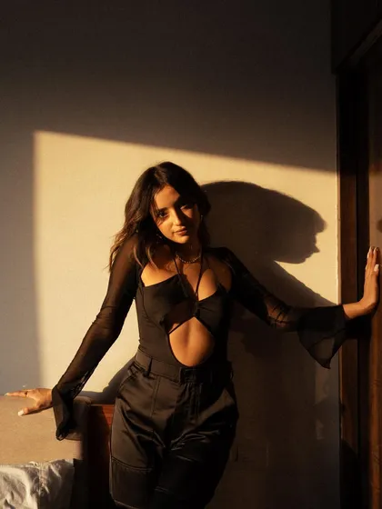 A portrait using the beautiful, warm light of the golden hour. The play of light and shadow on the wall and model creates a natural, intimate, and slightly dramatic feel.