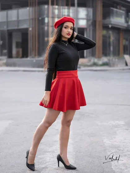 A full-length shot showcasing the complete Parisian-inspired outfit. The pose highlights the lines of the skirt and the confident stance, set against a clean, urban street for a modern fashion photo.