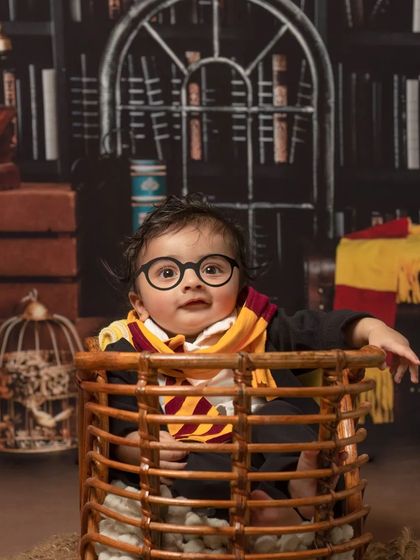 The cutest wizard in training. This baby Harry Potter shoot captures the adorable side of magic, complete with tiny glasses and a Gryffindor scarf.