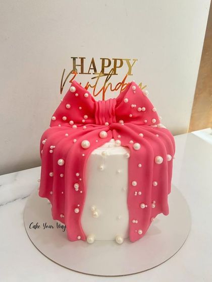 Bow down to the birthday beauty. This cake is designed to look like a gift, with a large pink fondant bow and edible pearls.