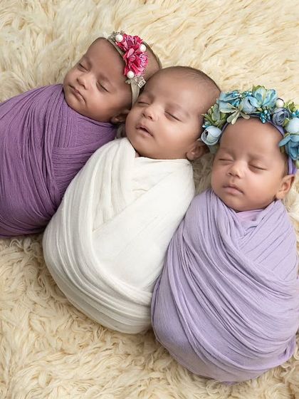 A different angle of the swaddled triplets, showing how they naturally cuddle close to each other.
