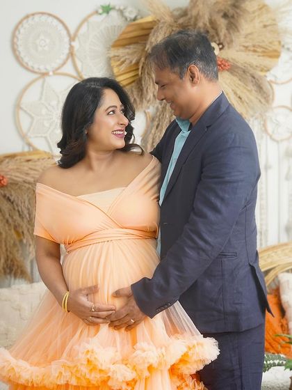 A loving gaze between the couple in my boho studio setup. This portrait captures the happiness and excitement of their pregnancy journey.
