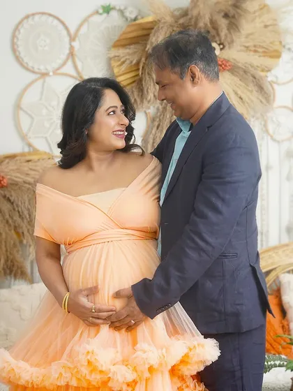 A loving gaze between the couple in my boho studio setup. This portrait captures the happiness and excitement of their pregnancy journey.