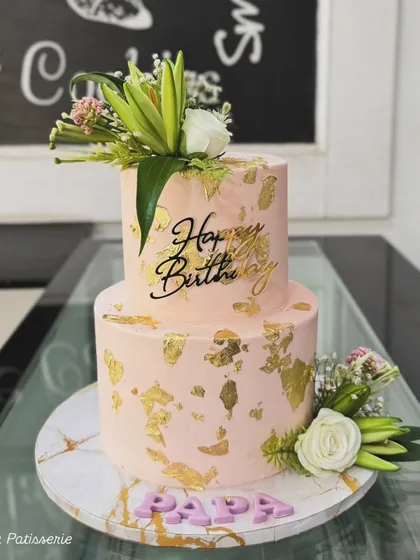 A two-tiered peach cake for "Papa," decorated with gold leaf and fresh flowers. A beautiful way to celebrate a father's birthday.
