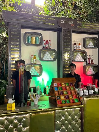 The complete coffee station, featuring a menu board, a selection of flavored syrups, and a variety of tea bags, catering to all tastes.