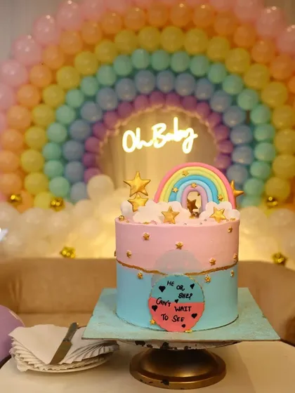 The centerpiece of the baby shower: a gorgeous gender reveal cake that perfectly matches the pastel rainbow decor. Every element is coordinated to enhance the theme.